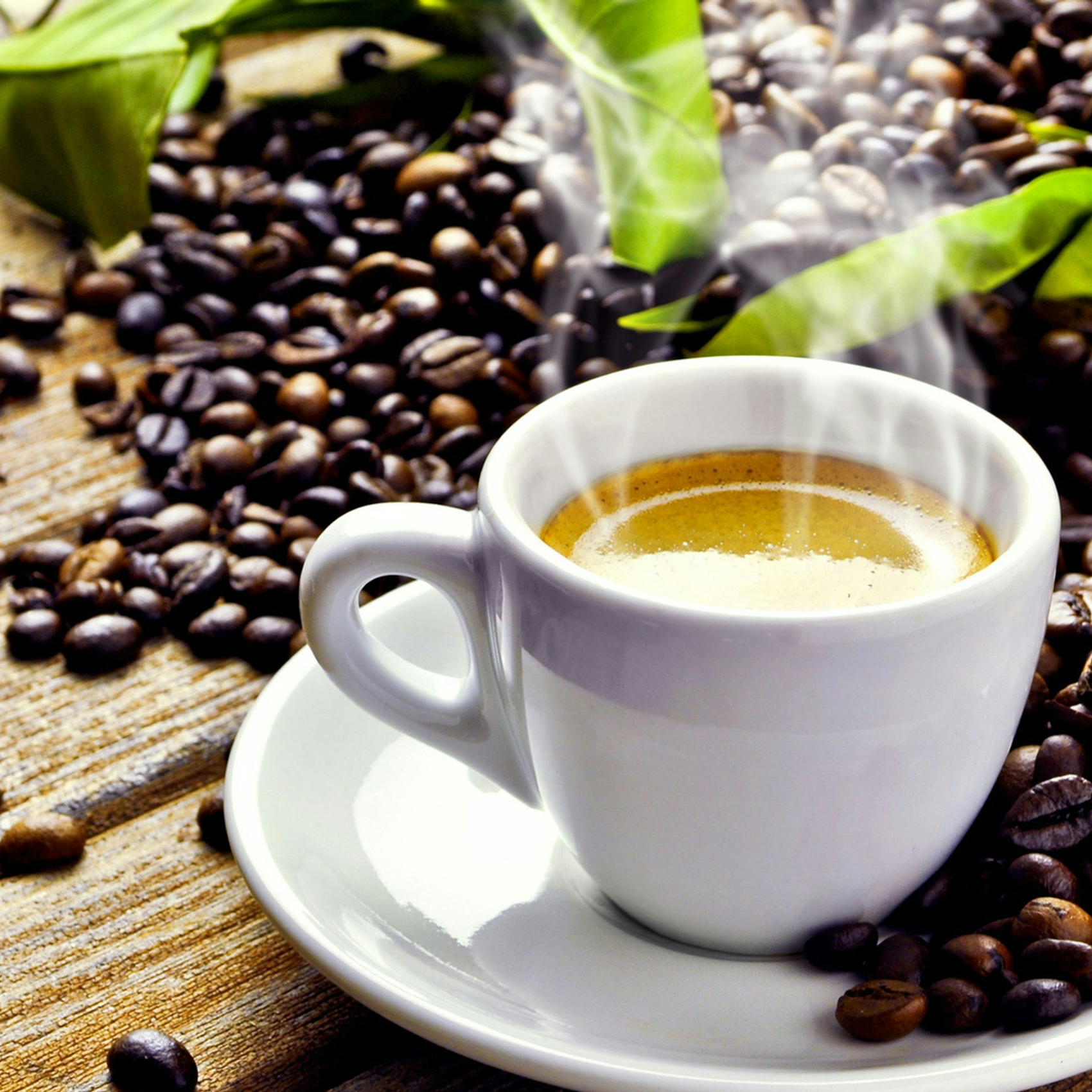 white ceramic mug on top of white ceramic saucer surrounded with coffee beans
